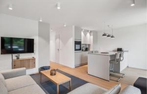 ein Wohnzimmer mit Couch und Tisch und eine Küche in der Unterkunft 2 Bedroom Lovely Apartment In Tossens in Stick