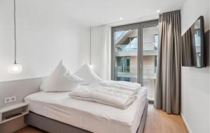 a bedroom with a bed with white sheets and a window at 1 Bedroom Stunning Apartment In Tossens in Stick +11 photos