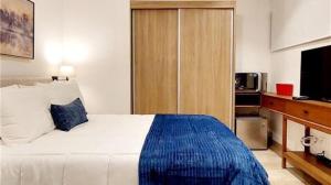 a bedroom with a large bed and a television at Serenada Boutique Room Near 5th Ave in Playa del Carmen