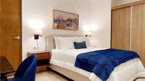 a hotel room with a bed and a blue chair at Serenada Boutique Room Near 5th Ave in Playa del Carmen