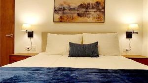 a bedroom with a large bed with two lamps at Serenada Boutique Room Near 5th Ave in Playa del Carmen