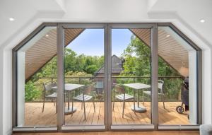 Zimmer mit Blick auf einen Balkon mit Tischen und Stühlen in der Unterkunft 2 Bedroom Gorgeous Apartment In Tossens in Stick