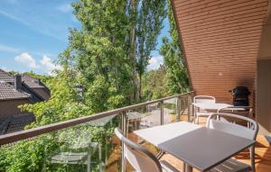 einen Balkon mit einem Tisch, Stühlen und Bäumen in der Unterkunft 2 Bedroom Gorgeous Apartment In Tossens in Stick + 11 Fotos