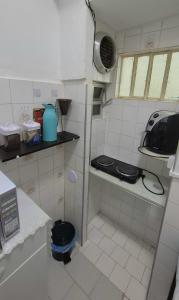 a small kitchen with a stove and a sink at Apartamento no Centro - Condomínio Lido in Miguel Pereira