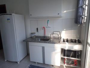 a small kitchen with a sink and a refrigerator at Studio em São José SC in São José +4 photos