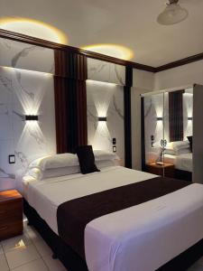 a bedroom with a large bed and two mirrors at Moatoga Hotel in Apia