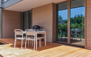 eine Terrasse mit Tisch und Stühlen auf einem Deck in der Unterkunft 1 Bedroom Amazing Apartment In Tossens in Stick