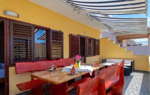 a dining room with a wooden table and red chairs at Two-Bedroom Apartment In Sibenik in Šibenik