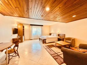 a hotel room with a bed and a table and chairs at Hotel Villa Passaredo in Tijucas do Sul
