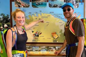 a man and a woman standing in front of a map at Cacao Hostel Santa Marta in Santa Marta