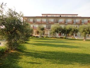 a large building with a lawn in front of it at Elaia Garden Hotel in Sperlonga