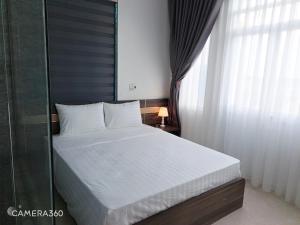 een slaapkamer met een wit bed met een raam bij GolDen RiCe in Thái Thụy +4 foto's