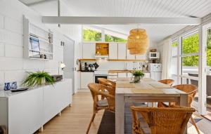 a kitchen and dining room with a table and chairs at Cassiopeja in Strandby Gårde