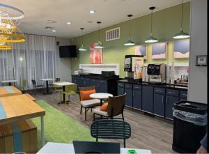 a cafeteria with tables and chairs and a kitchen at Spark by Hilton Fort Stockton in Fort Stockton