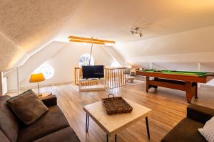 a living room with a couch and a pool table at Ferienwohnung im Gulfhof in Krummhörn