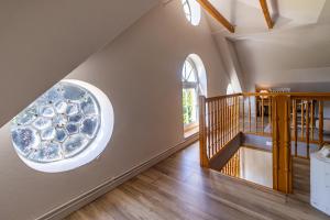 an attic hallway with a round window and a spiral staircase at Ferienwohnung im Gulfhof in Krummhörn