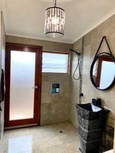 a bathroom with a door and a mirror and a sink at Salty Blue Beach House in Kalbarri