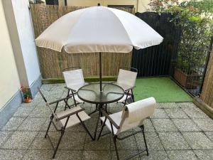 a table and chairs with an umbrella on a patio at Casa Noè - cozy home with big terrace and private box in Turin