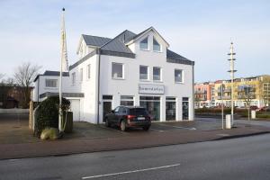 a black car parked in front of a white building at Andreas-Nielsen-Str. 12, W2 in Westerland (Sylt)
