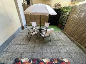 a patio with a table and chairs and an umbrella at Casa Noè - cozy home with big terrace and private box in Turin