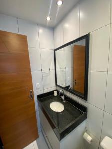 een badkamer met een wastafel en een spiegel bij Loft Lampião in Campina Grande