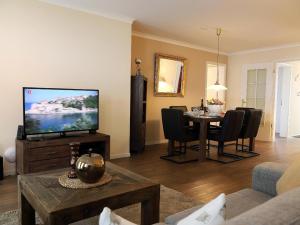 ein Wohnzimmer mit einem TV und einem Esstisch in der Unterkunft Bomhoffstr. 15, Whg. 4 in Westerland