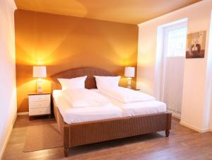 ein Schlafzimmer mit einem großen Bett mit weißen Laken und Kissen in der Unterkunft Bomhoffstr. 15, Whg. 4 in Westerland
