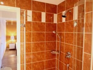 ein Badezimmer mit einer Dusche mit braunen Fliesen in der Unterkunft Bomhoffstr. 15, Whg. 4 in Westerland + 13 Fotos