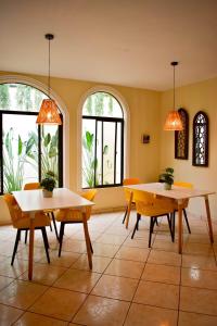 two tables and chairs in a room with windows at Hotel Boutique Valverde Santa Elena in San Salvador