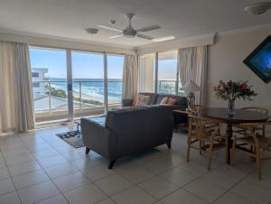 a living room with a couch and a table at Pacific Surf Absolute Beachfront Apartments in Gold Coast