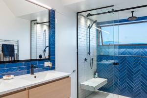 a bathroom with a glass shower and a white sink at Sunrise Serenity with Hot Tub in Christchurch +24 photos