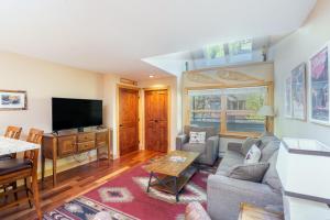 a living room with a couch and a tv at Cimarron Lodge 35 condo in Telluride