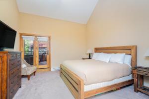 a bedroom with a bed and a television and a dresser at Cimarron Lodge 35 condo in Telluride