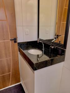 un baño con lavabo y espejo en Loft Biliu, en Campina Grande
