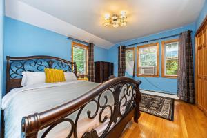 a bedroom with a bed with blue walls and windows at Extremely Spacious Home 10 Mins to The Encore in Medford