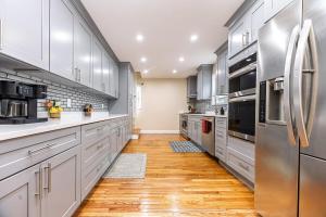 a kitchen with white cabinets and stainless steel appliances at Extremely Spacious Home 10 Mins to The Encore in Medford