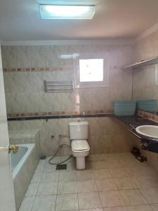 a bathroom with a toilet and a tub and a sink at فيلا بالساحل الشمالي ديار in Dawwār Abū Maḩrūs +17 photos