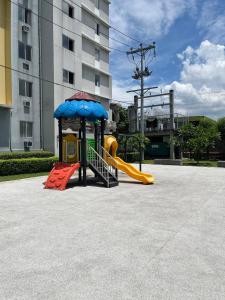 un parque infantil con tobogán y sombrilla en Tiny's BnB, en Davao City