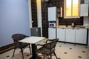 a kitchen with two chairs and a table and a table at موعد الضيافة للشقق المخدومة in Riyadh