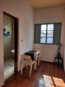 ein Raum mit einem Tisch und Stühlen und einem Fenster in der Unterkunft Pousada Silva Guedes in São Thomé das Letras