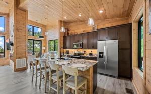 Stunning Cabin for 6 with Hot Tub & Pool Table في سيفيرفيل: مطبخ مع طاولة طويلة مع كراسي وثلاجة