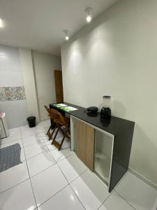 eine Küche mit einer schwarzen Theke und einem Tisch in der Unterkunft Loft Marinês in Campina Grande