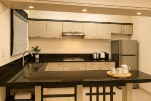 a kitchen with white cabinets and a black counter top at Queen room only near sm mall Fast Wifi in Malabañas