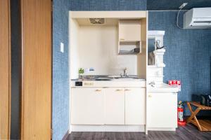 a kitchen with white cabinets and a sink at Silk Court 405 in Chitose
