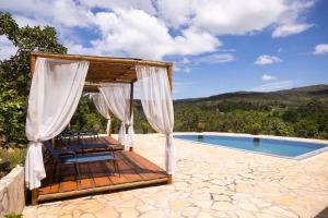 a gazebo with chairs next to a swimming pool at Refúgio Tangará in Rio Acima