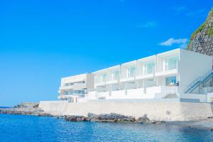 un edificio blanco en la orilla del agua en ビーチテラス房総, en Futtsu