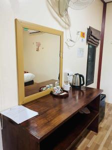 a mirror on a wooden desk in a room at Khao Sok Nung House in Khao Sok
