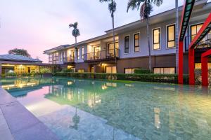 a swimming pool in front of a building at Antiya Hotel Phuket in Phuket