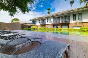 a courtyard with chairs and a building with a pool at Antiya Hotel Phuket in Phuket Town