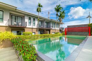 a swimming pool in front of a building at Antiya Hotel Phuket in Phuket +125 photos